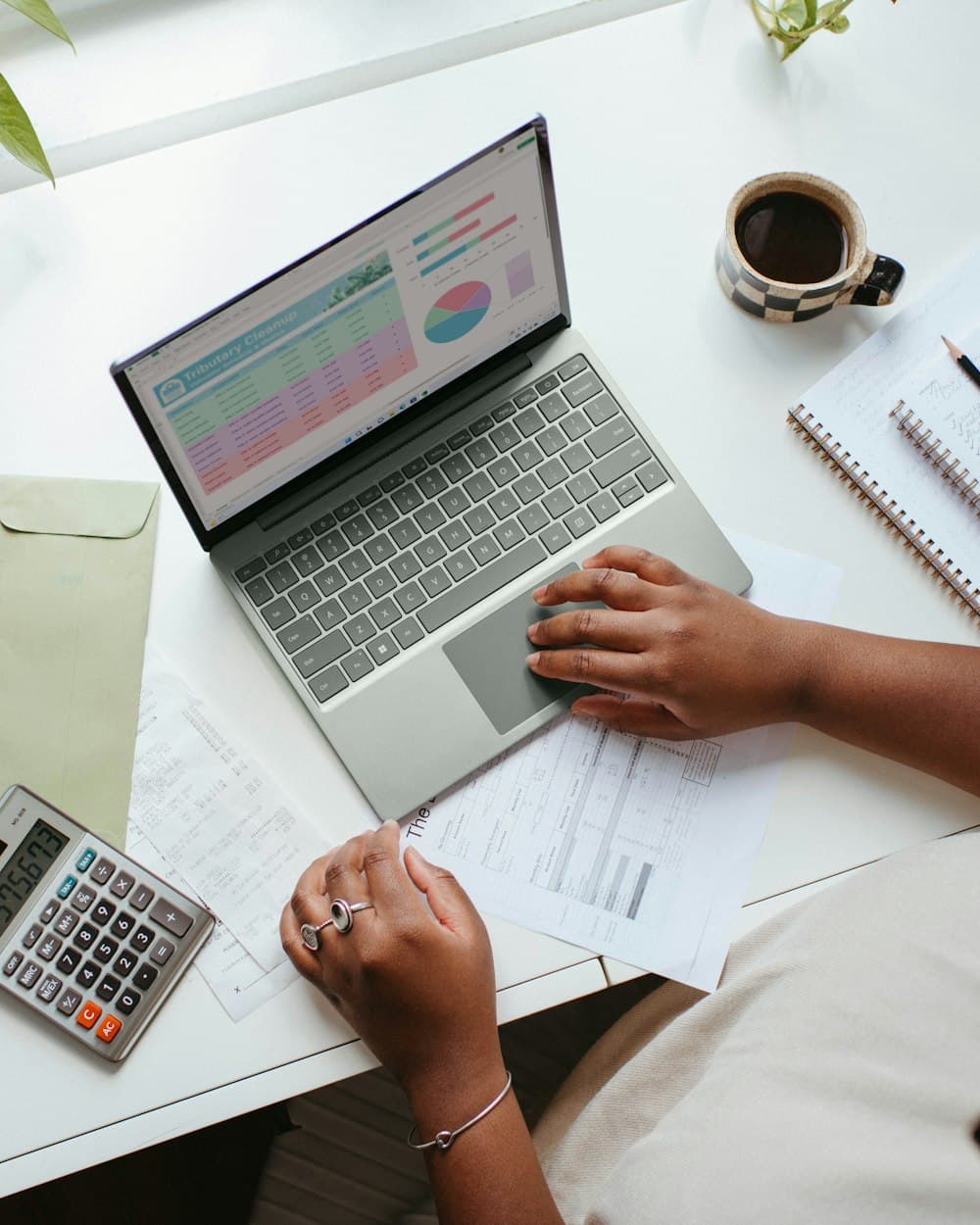 Escritorio claro con un notebook, un cuaderno y una taza de café.